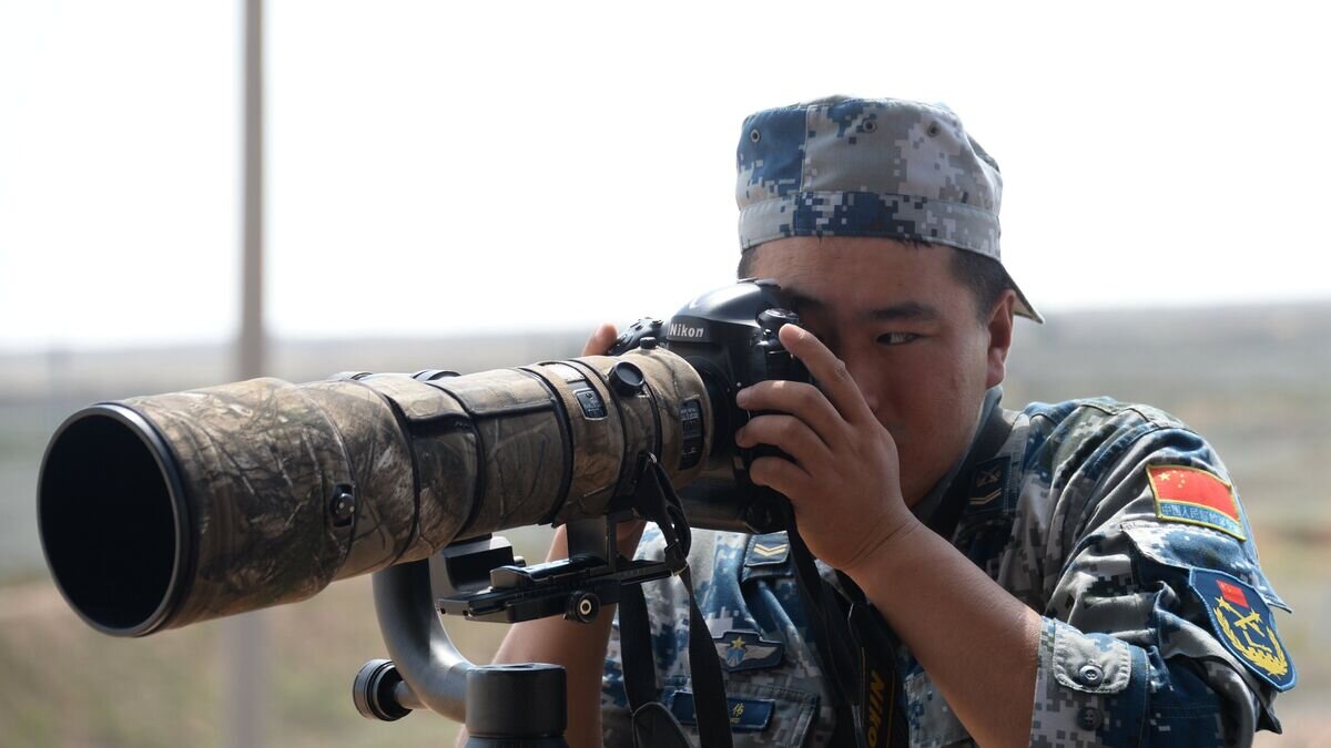    Военнослужащий армии Китая фотографирует во время международного конкурса "Ключи от неба"© РИА Новости / Кирилл Каллиников