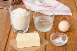 ШАГ 1:
Для приготовления теста нам потребуются: мука, холодное сливочное масло, ледяная вода и соль. А чуть позже также потребуется яйцо для смазывания и, по желанию, немного семян кунжута.