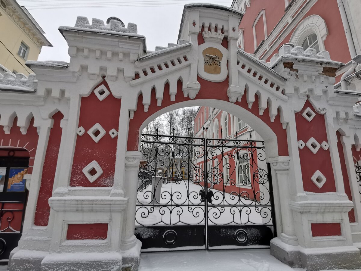  Ворота рядом со зданием представляют собой арочный проезд с двумя калитками  и стилизованы под романское зодчество. Над аркой помещён герб с пушкой и цифрами «1812».