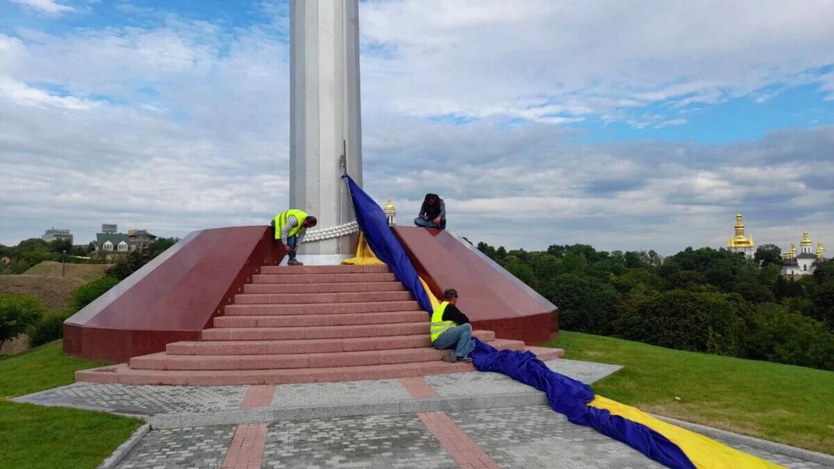    Сотрудники коммунальных служб снимают самый большой флаг Украины в Киеве© Фото : Vesti.ua