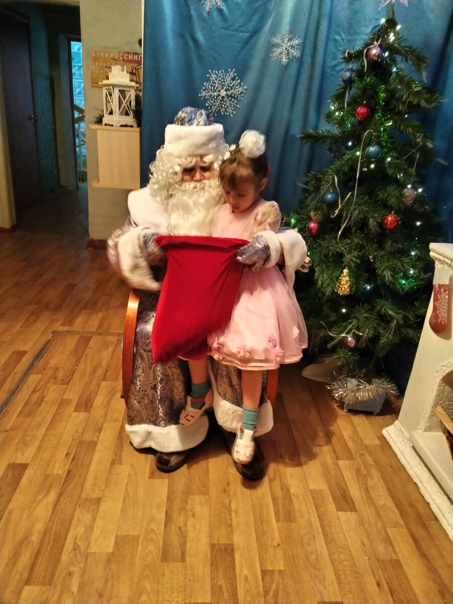 Мар'яна выбирает себе конфетку в мешке у дедушки мороза🙂