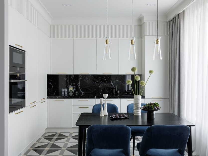 Зона кухни компактная и небольшая, но оснащена всем необходимым. Основное хранение организовано в пеналах по стене, которая примыкает к душевой. «Принципиальным моментом для меня было, чтобы столешница на стыке со шкафами на углу шла в линию, без маленького уголка, который часто бывает в таких случаях, когда об этом не думают заранее. Вместе с мастерами Giulia Novars мы проработали размеры угловых заглушек, выноса столешницы, расположение и габариты ручек, а также траектории открывания фасадов, чтобы ручки друг другу не мешали». Кухня, витрина, Giulia Novars. Столешница — из гранита Crystal Stone.