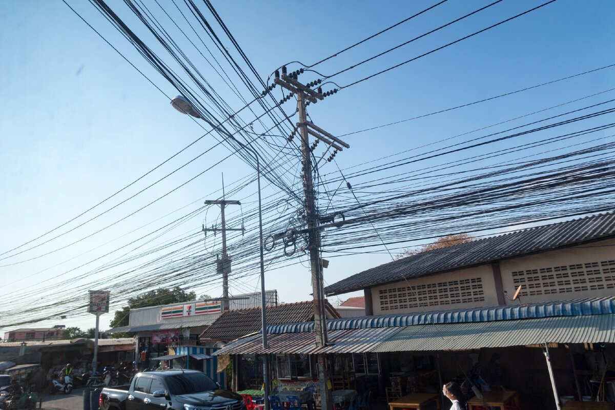 Большое количество проводов на уличных столбах в Таиланде. Причина всего – сабай