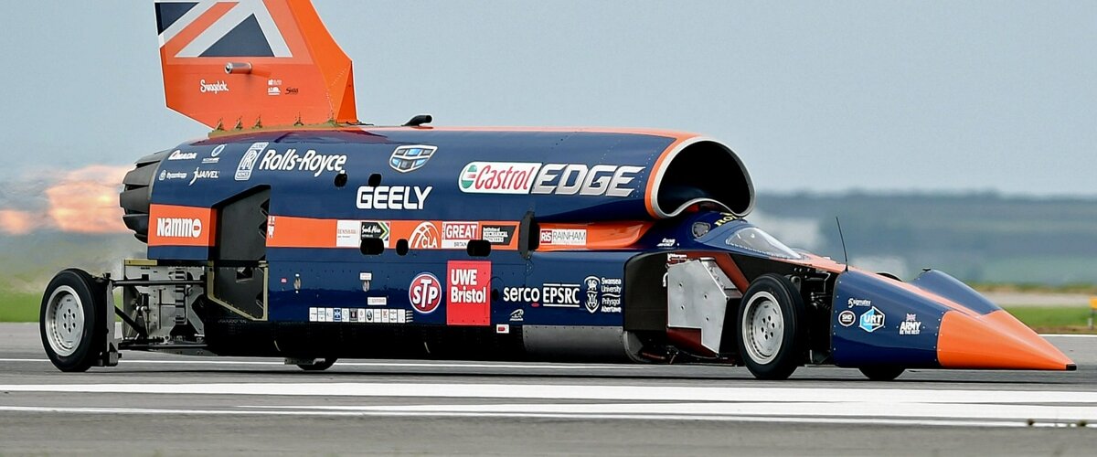Британский Bloodhound — это сигарообразная машина, которую приводит в движение реактивный двигатель. Главная цель проекта — установить новый наземный рекорд скорости, преодолев отметку в 1000 миль в час — то есть 1609 км/ч. По расчетам, машина-ракета способна развить скорость около 1700 км/ч.
Однако после публичной демонстрации возможностей компания-создатель разорилась. В декабре уникальный автомобиль выкупил бизнесмен Иэн Вархерст. Он говорит, что ради него разбор Bloodhound на запчасти и металлолом остановили в последний момент. В ангар он приехал вместе с детьми и увидел, насколько их вдохновил сумасшедший проект. «Я знал, что если я уйду, не заключив сделку, это будет конец. И не мог этого допустить», — цитирует его Guardian.

Изначально Вархерст планировал подыскать автомобилю-ракете место в каком-нибудь автомобильном музее, но теперь говорит, что передумал. Bloodhound не должен стоять на месте.
Теперь Вархерст возвращается к изначальному плану: попытке превзойти 1000 миль в час на поверхности соляного озера в ЮАР. Точные даты он, впрочем, не называет — сначала надо согласовать логистику и привлечь спонсоров.

«Мы ныряем в неизвестность, и это удивительно. Ни у кого нет наземного транспорта, который бы развивал такую скорость, так что и проблемы с шоковыми волнами и загрузкой будут за пределами нашего предыдущего опыта», — говорит бизнесмен.

Впрочем, большая часть старой команды, по данным Guardian, осталась в проекте с новым владельцем. Включая одного из ключевых людей для успеха проекта — бывшего летчика Королевских ВВС Энди Грина, которому доверили пилотировать Bloodhound. Сейчас Грину принадлежит действующий рекорд скорости: в 1997 году он разогнал реактивный автомобиль Thrust SSC до 1230 км/ч.

Простым смертным надежду испытать подобные скорости вблизи поверхности Земли дает реализация концепции Hyperloop — вакуумных поездов будущего. В апреле должны состояться первые испытания капсулы в полноценном тоннеле.