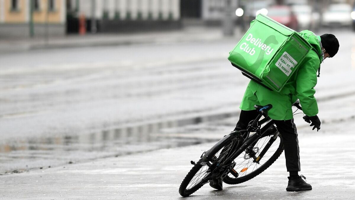    Курьер службы доставки Delivery Club едет на велосипеде на одной из улиц в Москве.© РИА Новости / Владимир Астапкович
