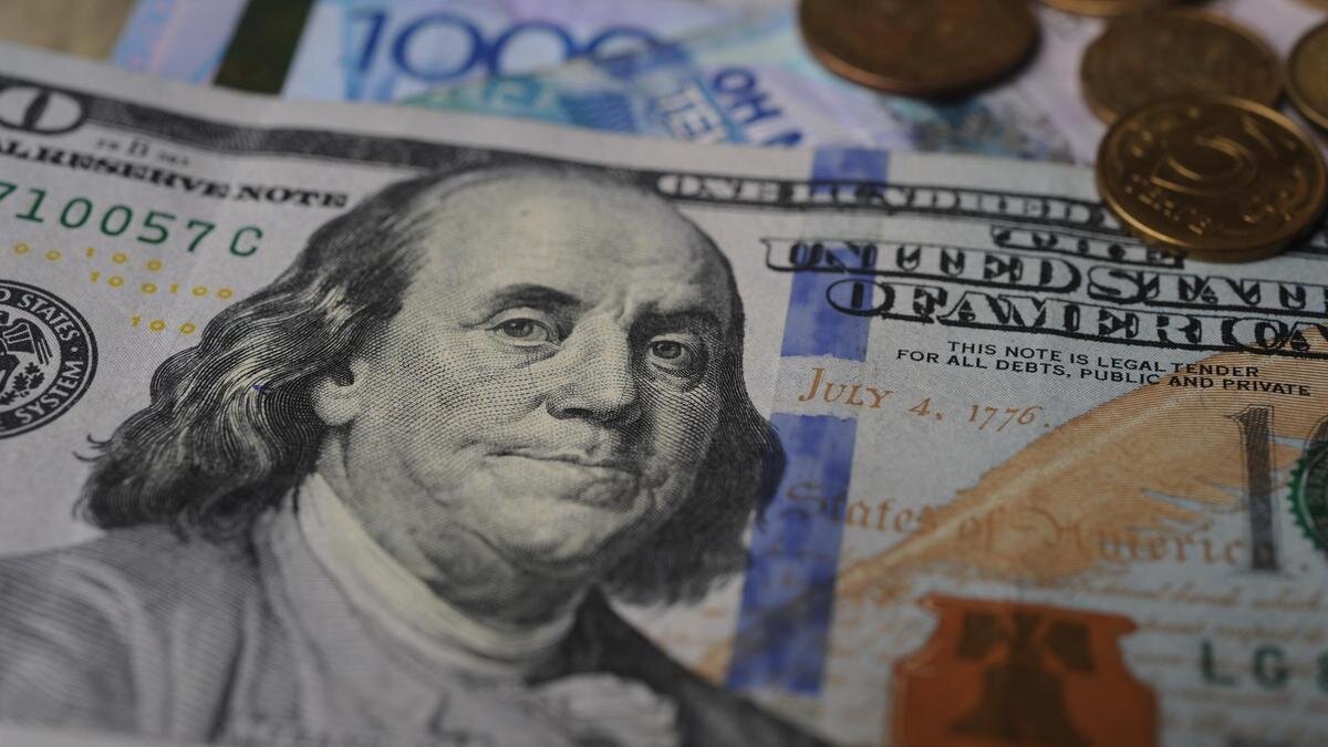    Купюра доллара лежит на купюрах тенге NUR.KZ / Владимир Третьяков