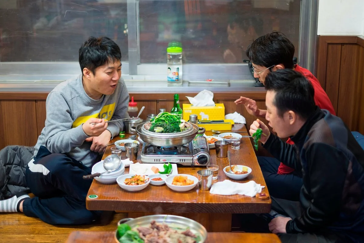 Покажи где едят. Корейское застолье. Японцы за столом. Корейцы за столом. Корейцы за столом в ресторане.