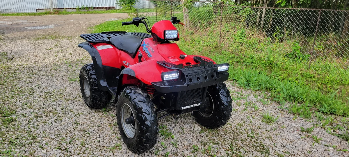 Передний багажник бы побольше! Но американцы решили под ним разместить бак. Светодиодные фары не портят классический дизайн. Источник фото - https://auto.ru/atv/used/sale/polaris/xplorer_400/4079534-ae52332a/