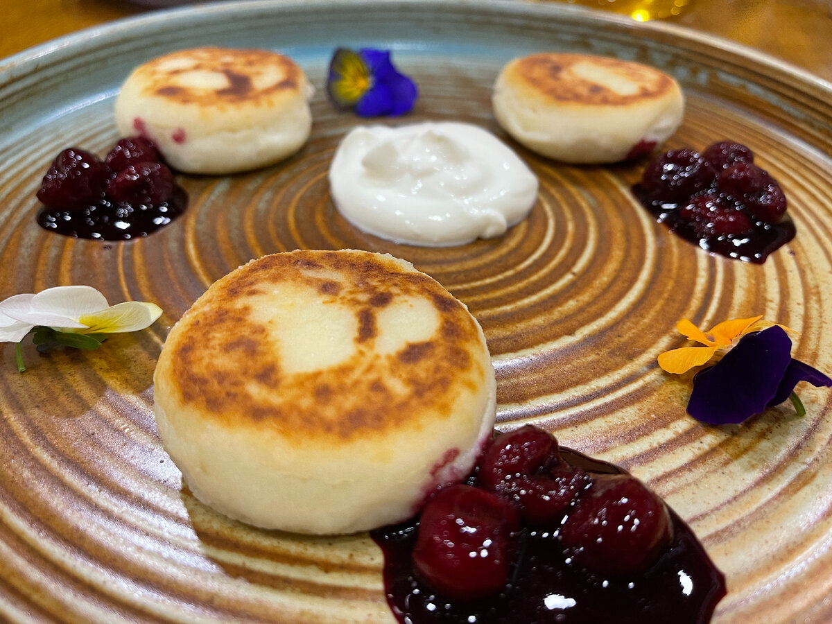 На фото сырники со сметаной и вареньем