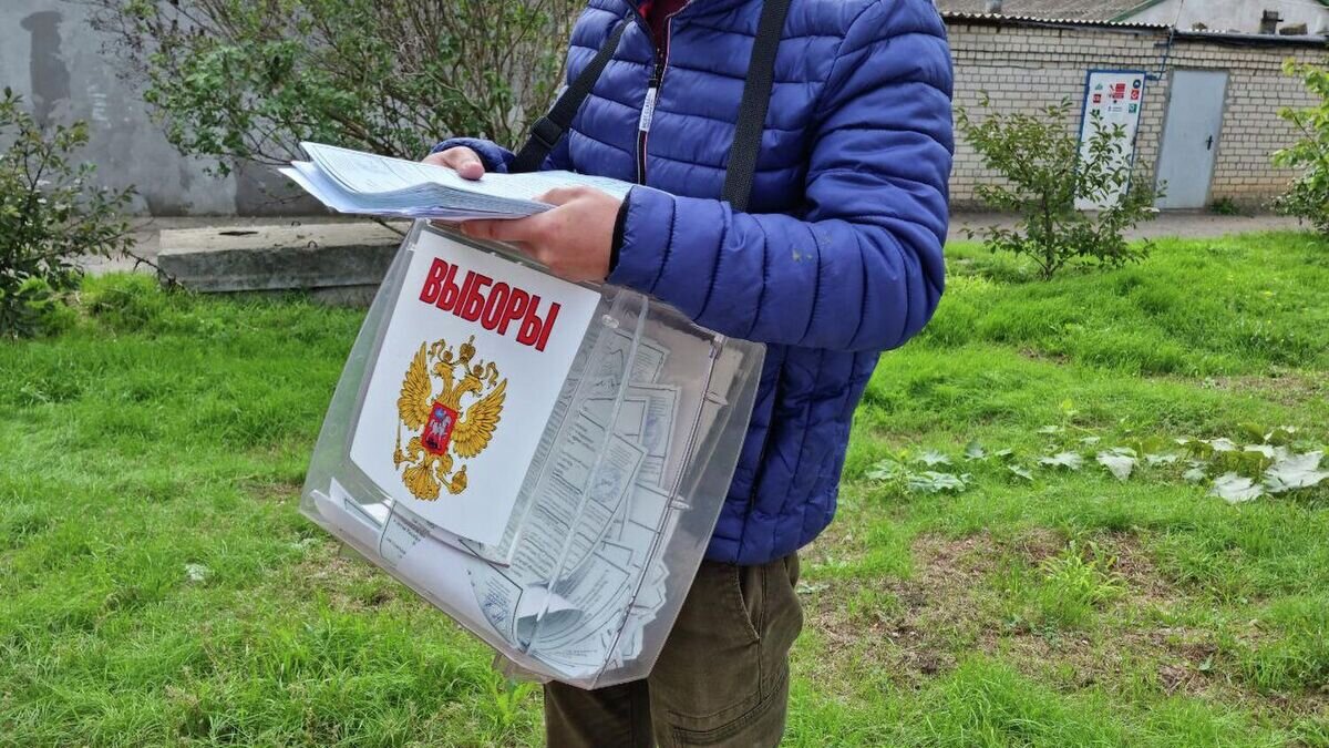    Сотрудник выездной избирательной комиссии с переносной урной для голосования на референдуме на избирательном участке в Чернобаевке© РИА Новости / РИА Новости Крым