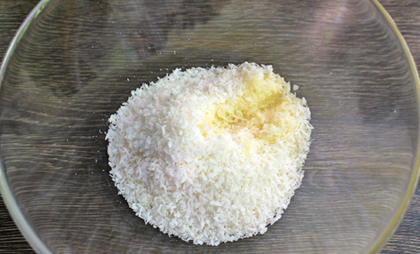 
Небольшую порцию кокосовой стружки (около 50 г) выделяем для обсыпки готовых конфет. Остальное количество высыпаем в удобную глубокую миску. Для аромата бросаем ванилин на кончике ножа или добавляем экстракт ванили. Затем вливаем растопленное сливочное масло.