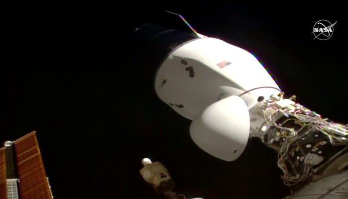 На этом изображении с телевидения НАСА космический корабль Dragon компании SpaceX стыкуется с Международной космической станцией, 7 декабря 2020 года.