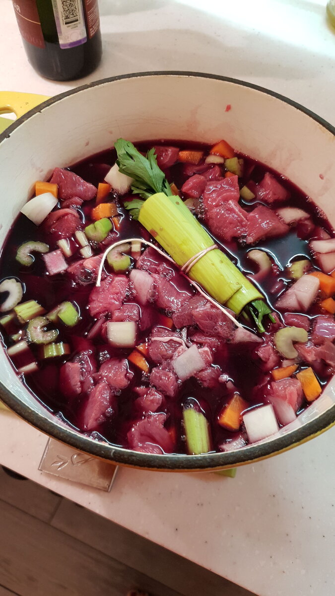 Маринуем мясо примерно за сутки до готовки, зеленая палочка в центре - букет Гарни, перевязанный кулинарной нитью в листе порея 