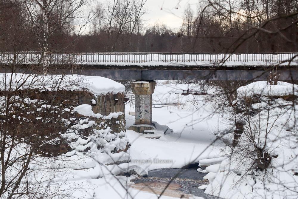Автомобильный мост через реку Мга на фоне руин старого моста