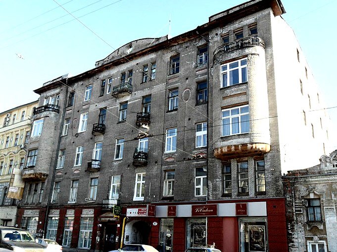 Фасад завершен парапетными стенками - центральной  с лучковым изгибом, круглым проёмом и прямыми  по бокам. 