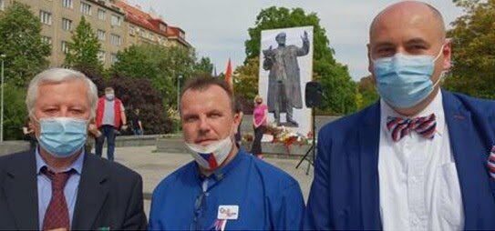 Представитель Компартия Маравии и Чехии Йозеф Скала, общественный активист Юрий Черногорский и староста района Прага -11 Роберт Вашичек на фоне плаката, установленного на месте демонтированного памятника маршалу Ивану Коневу. Прага, 9 мая 2020 г. Источник: mk.ru