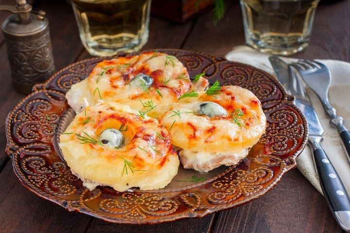 Свинина под ананасами  Что необходимо (на 5 порций):      мясо – 500 г;     низкокалорийный майонез – 100 г;     консервированные ананасы – 1 банка;     твердый сыр «Российский» — 100 г;     соевый соус – 100 г;     сироп – 100 г;     подсолнечное масло;     молотый черный перец.  Процесс приготовления:      Банку с ананасами открыть, сироп слить в отдельную посудину.     Мясо промыть под проточной водой, просушить.     Нарезать на куски размером немного шире кольца ананаса и толщиной  1-1,5 см, отбить.     Сделать маринад из сиропа и соевого соуса, залить им мясо. Оставить в  прохладном месте на 1,5 часа.     Форму смазать маслом, выложить свинину с перцем и солью.     Сверху накрыть кольцами ананаса.     Полить майонезом.     Посыпать крупно натертым сыром, поставить в разогретый духовой шкаф  на 40 минут, готовить при температуре 180 градусов Цельсия.     Украсить овощами и зеленью, подавать в горячем виде.... 