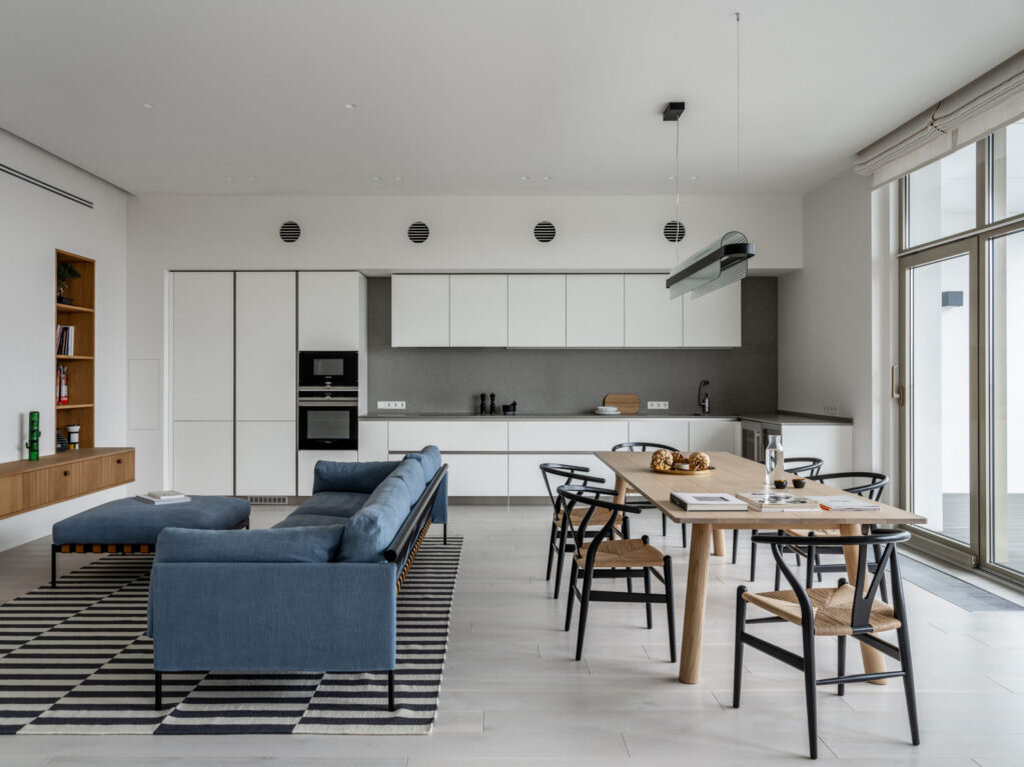Квартира-лайнер по проекту Бориса Денисюка, 170 м². Зона гостиной, столовой и кухни. Стол Bull, B&B Italia; стулья, Carl Hansen; люстра Nami, Kundalini; кухня, Hanak.