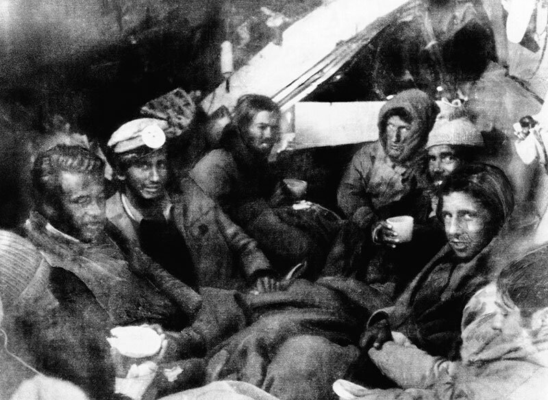 Фото: 8 выживших сидят в иглу, которое они сделали для себя. Один из мужчин на этой фотографии (третий слева) был на фотографии выше, прислонившись к сиденью со своим другом (третий справа на фотографии выше)