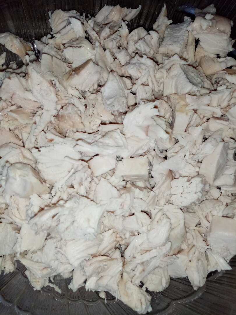 Сварить в подсоленной воде  куриную грудку (1 шт), остудить и порезать мясо в салатник.