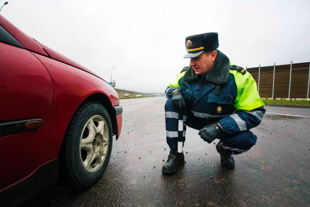 ГАИшник возле колеса автомобиля. Источник: Яндекс Картинки