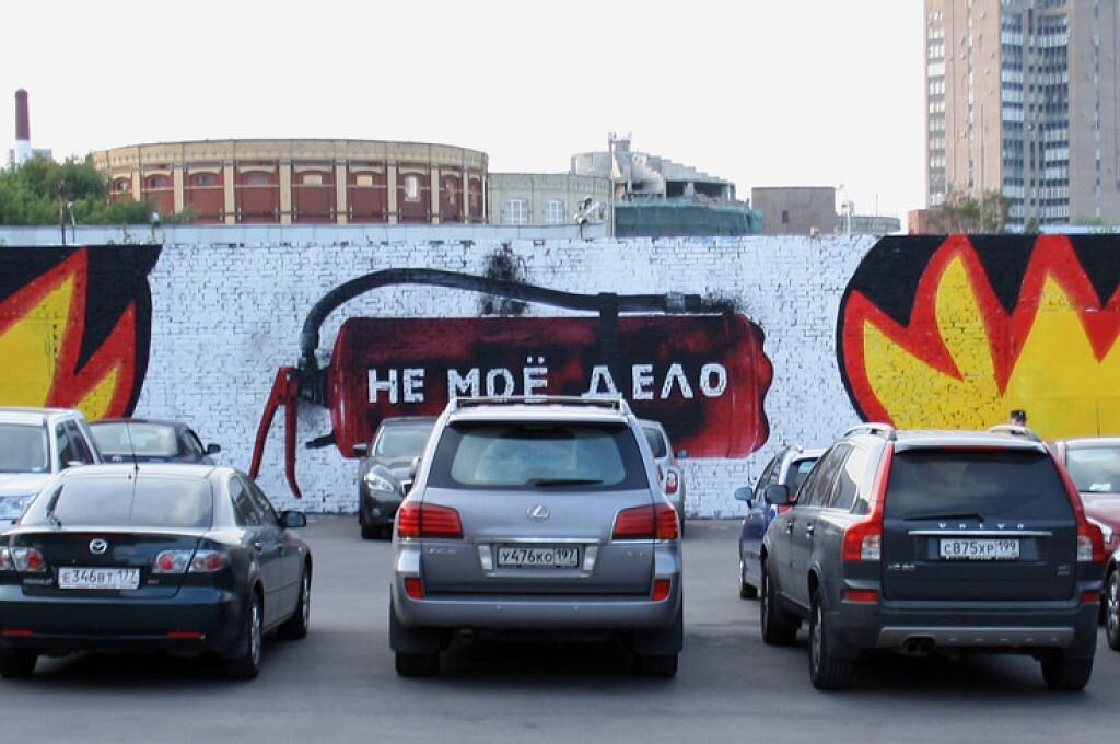 Работа украинского художника Романа Минина, Из-за припаркованных машин он не смог реализовать изначальную идею, которую согласовал с администрацией. Поэтому дополнил работу Игоря Дизеби (автора предыдущего слоя с огнетушителем), чтобы выразить своё видение ситуации и  конфликт между обывателями и художниками. На мой взгляд, работа без привязки к этой ситуации несёт еще более глубокий смысл русской ментальности.