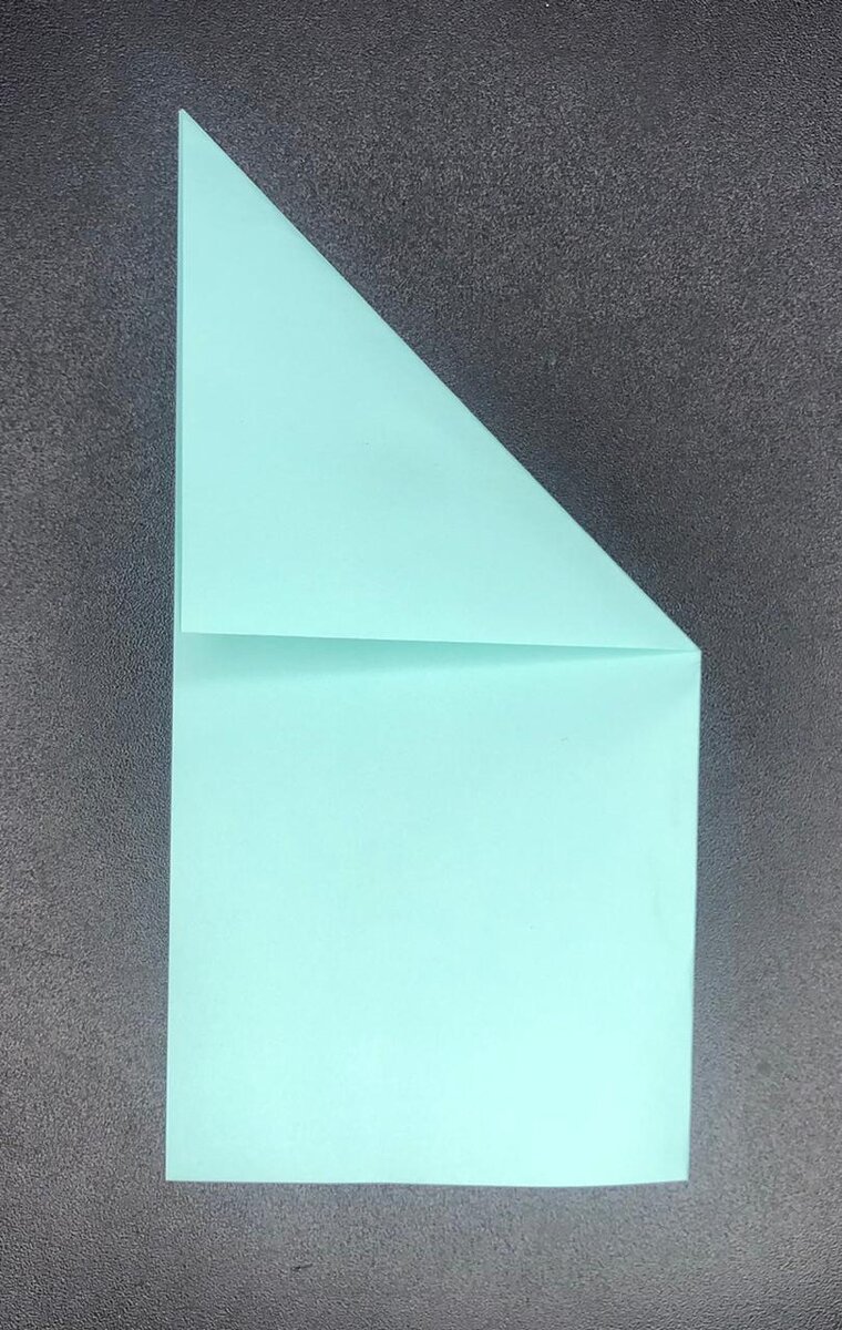 Прорабатываем складки. Складываем правый верхний угол к левой стороне и разворачиваем.