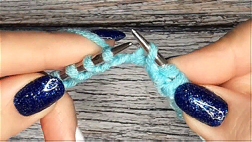 Правую спицу направьте под наборным краем, захватите рабочую нить, лежащую на указательном пальце, и выведите образовавшуюся петлю на себя