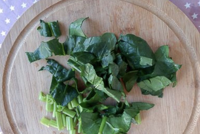 Приготовление пирога со шпинатом начинается с начинки. Для этого отрежьте корешки у листьев шпината, предварительно хорошо промыв листья от грязи. Нарежьте листья и черешки на кусочки около 1 см шириной.