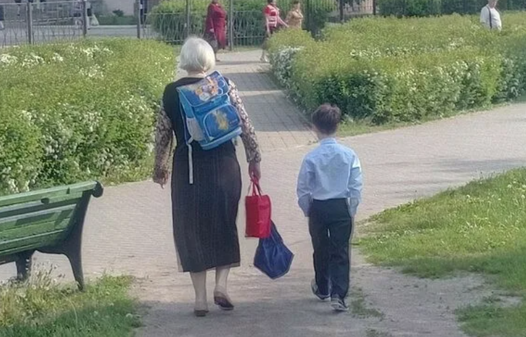 Бабушка внука в школу провожает.