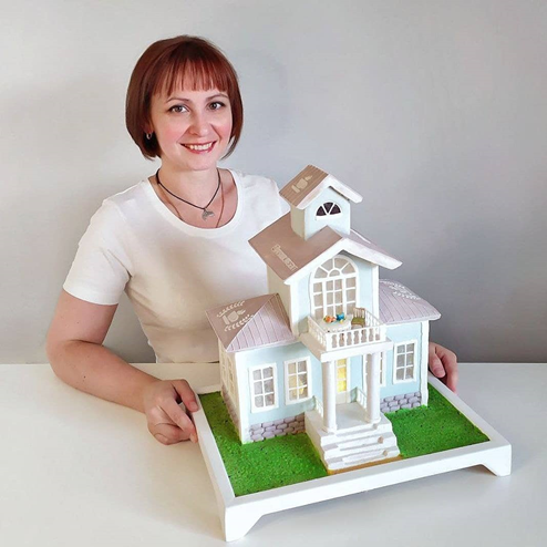 на фото: Катя Замолотчикова и пряничный домик, который Катя изготовила по моему заказу в качестве символа нашей клубной выставки «Чай, кофе и десерты», которую мы провели в отеле «Метрополь» 12 июня 2021 года.