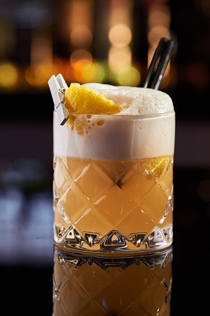 Хотите попробовать "Виски сауэр"? Это крепкий кислый коктейль на бурбоне с добавлением яичного белка и лимонного сока. Входящий в состав сахарный сироп уравновешивает кислые компоненты коктейля, и на выходе он получается гармоничным и нежным. "Виски сауэр" известен с 1870-го года, так что этот напиток поистине классический.