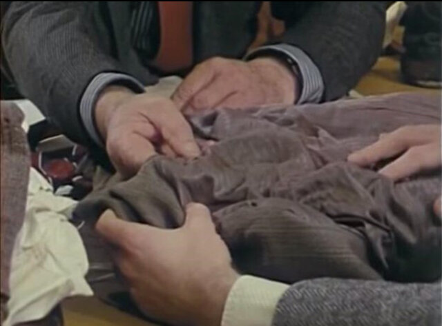 Кадр из фильма, где детектив Лен Браун показывает особую строчку пиджака.