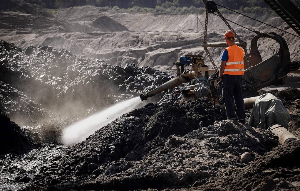 Работа гидромонитора - машина, подающая струю воды с огромным давлением и с расходом, почти в 500 литров в секунду. Только такая струя воды способна размыть "голубую землю" - грунт, в котором таятся куски янтаря. По сути, "голубая земля" - очень вязкая глина. 