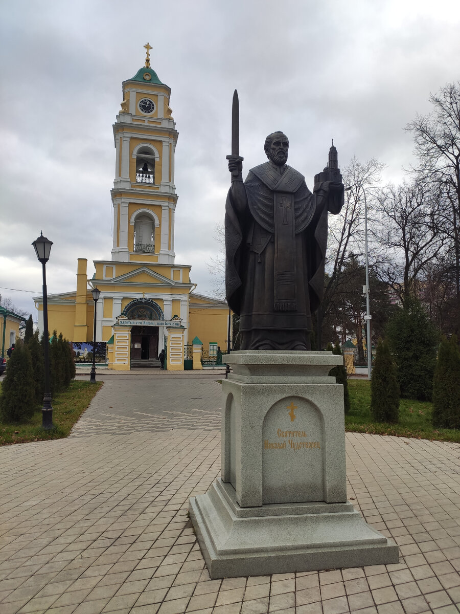 Памятник Николаю Чудотворцу на фоне Никольского собора, установлен в 2017 году, на памятник есть отметка "Скульптор Леонов А."