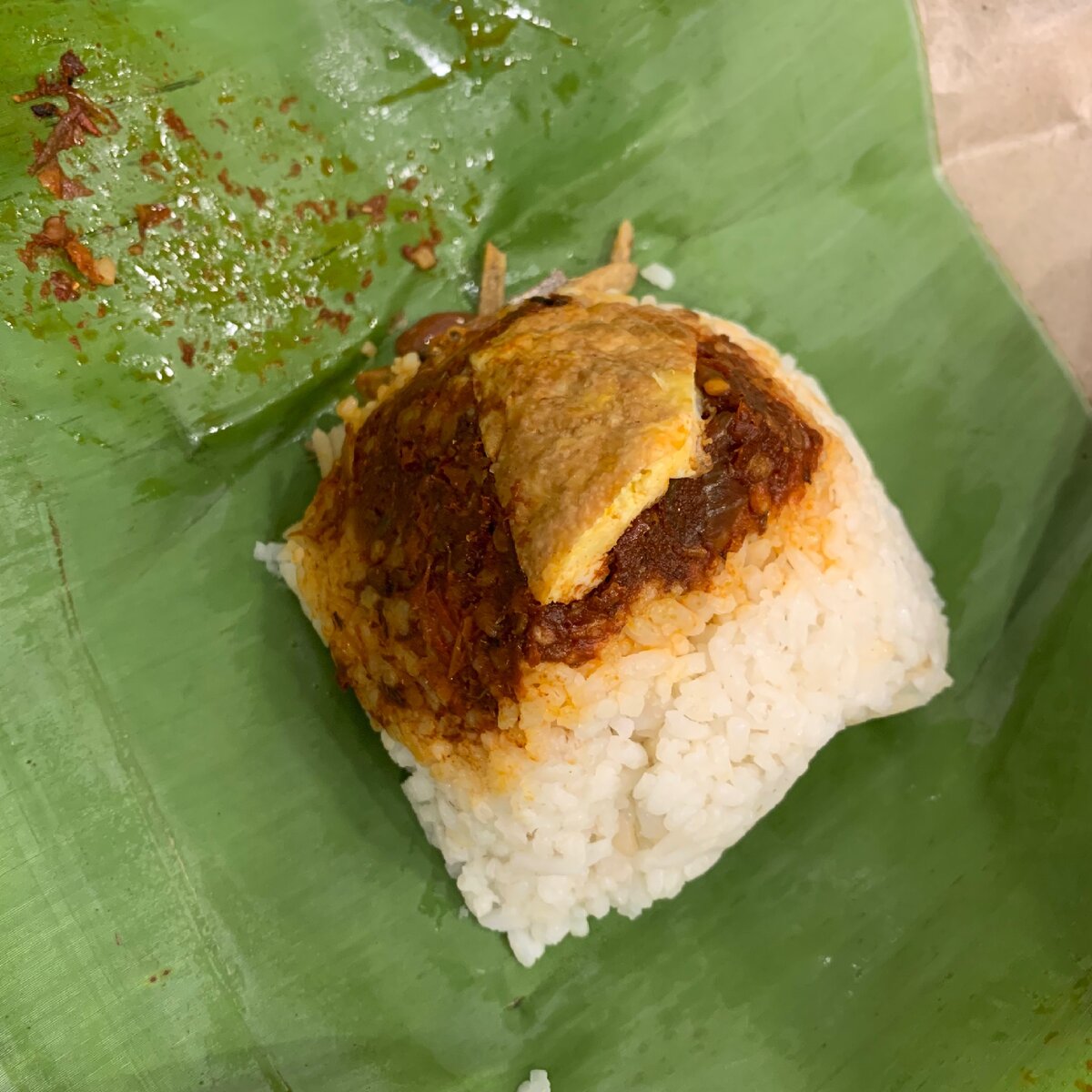 Nasi lemak - Рис приготовленный в кокосовом молоке с чили и яйцом сверху. Подается в банановом листе. Лист заворачивают в форме пирамидки.