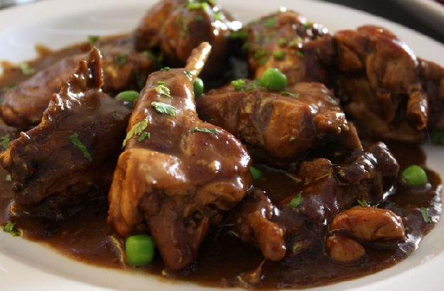 Ингредиенты: 	• тушка кролика – 1 штука;
	• белое сухое вино – 1 бутылка (750 мл);
	• лавровый лист – 1 штука;
	• мука – для обваливания мяса;
	• растительное масло – для обжарки;
	• репчатый лук – 1 штука;
	• соль, перец, специи – по вкусу.
Рецепт:
1. Мясо кролика разделить на порционные кусочки. Почистить и промыть.
2. Сложить крольчатину в емкость для маринования, залить белым вином (минимум на 2-3 см выше слоя мяса). Накрыть крышкой, оставить в холодильнике на ночь.
3. Достать мясо кролика из вина. Обсушить, посолить, поперчить, затем обвалять в муке. Маринад не выливать, он нужен для тушения.
4. Разогреть сковородку (глубокую) с растительным маслом. Обжарить мясо с двух сторон до золотистого цвета (примерно по 10 минут на каждую сторону).
5. Измельченный полукольцами лук добавить на сковородку. Посолить, поперчить, добавить лавровый лист и другие специи. Жарить пока лук не станет золотистым.
6. Добавить белое вино, довести до кипения, уменьшить огонь к минимуму, не закрывать крышкой 8-10 минут, чтобы из вина испарился спирт.
7. Накрыть сковородку крышкой. Тушить на слабом огне 90 минут до готовности (через 60 минут попробовать на вкус, при необходимости добавить больше соли и специй). Периодически доливать вино и перемешивать мясо.
