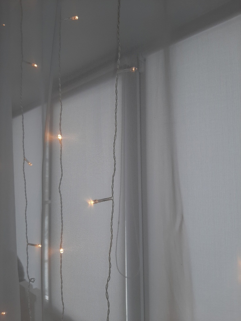 Гирлянда на большом окне. В темноте желтый свет создает  неповторимый уют. 