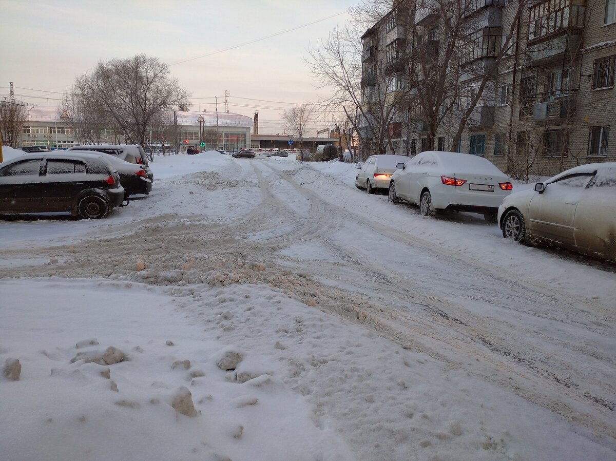 Вот такое месиво у нас во дворе. Я выезжал со стоянки, где на фото машины слева. Там под машинами образуется яма, а выезжать надо на горку, которая образовалась из-за чистки дороги трактором (лучше бы уж не чистили). На фото кажется не так страшно, потому что оно не передаёт в полной мере масштабы. Но снег рыхлый, тяжёлый и глубокий. Поэтому если неудачно припарковался, то можно и побуксовать (что я и сделал))).