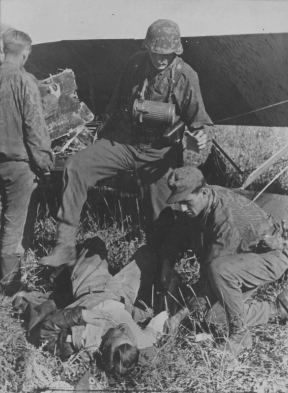 Солдаты SS у раненого советского летчика самолета У-2, сбитого на Курской дуге.