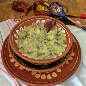 Впервые этот суп я попробовала в глубоком своем детстве у подружки в гостях. Как сейчас помню, как я пришла домой и не могла вменяемо объяснить маме, как это в супе плавали кружева. Все дело в том, что моя мама такой суп никогда не готовила, и даже после ее предположений, что возможно, там размешено яйцо, я не могла в это поверить и повторяла: не яйцо, а жидкие кружева. Моя мама, почему-то не признавала такой способ добавления яиц в суп и даже в щавельник всегда яйцо варила и нарезала уже вареное. Поэтому когда я выросла, то не не имела в своем меню ничего подобно. Но замужество внесло свои коррективы. Оказалось, что мама мужа не только часто готовит такой суп, но он его безумно обожает. Для него именно такой суп настоящий вкус детства и забывать о нем он не желает ни за что. Так пришлось мне вооружившись ручкой и блокнотом отправиться к свекровушки в гости, на мастер класс по приготовлению кудрявого супа с яйцом. После мастер класса приготовить его дома, получить одобрение своего самого главного критика, а вместе с ним и одобрение для публикации рецепта в блог.
Приступим к приготовлению?

Ингредиенты:
Бульон – 2-2,5 л.
Лук репчатый – 2 шт.
Помидоры – 1- шт.
Перец болгарский – 1 шт.
Картофель – 2-3 клубня.
Рис – ½ стакана.
Укроп – 1 пучок.
Петрушка – 1 пучок.
Зеленый лук – 1 пучок.
Яйцо – 3 шт.
Соль, перец, лавровый лист, кориандр зернами.
Приготовление:
По сути бульон можно заменить водой, тогда суп будет более легкий. Но, у меня был замороженный бульон, который я разморозила и на его основе сварила эту вкуснятину.
1. Лук, картофель и чистим и промываем под холодной проточной водой.
2. Укроп, петрушку и помидоры промываем под холодной проточной водой.
3. Картофель нарезаем кубиком и отправляем в бульон вариться до полуготовности.
4. Рис промываем под холодной проточной водой и пока убираем его в сторону.
5. Лук нарезаем перьями, болгарский перец и помидоры мелким кубиком.
6. Разогреваем на сковороде несколько ложек растительного масла и обжариваем в нем лук до прозрачности, затем добавляем в него болгарский перец и обжариваем еще несколько минут, пока перец не станет мягким. Затем добавляем помидоры, перемешиваем, обжариваем все вместе еще пару минут и выключаем огонь.
7. Тем временем наш картофель почти сварился, добавляем в нему рис и варим все вместе минут 5-7.
8. Яйца разбиваем в небольшую миску и перемешиваем вилкой до однородности.
9. Когда картофель будет готов добавляем в бульон нашу зажарку и мелко нарезанную зелень.
10. Затем интенсивно размешивая бульон вливаем яйца.
11. Добавляем в суп специи по вкусу, у меня это соль, черный молотый пере, черный перец горошком, лавровый лист и кориандр. Еще я добавляю не много кислого борща (это такая специфическая молдавская жидкость для первых блюд, не знаю чем его заменить)
Даю супу закипеть, накрываю крышкой, выключаю и даю ему постоять, настояться.
Через час можно наслаждаться супом.