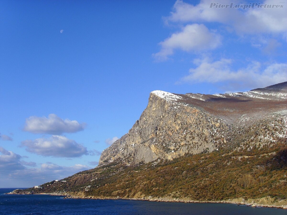 Первый снег в Ласпи на вершине горы Куш-Кая. На небе луна днём.