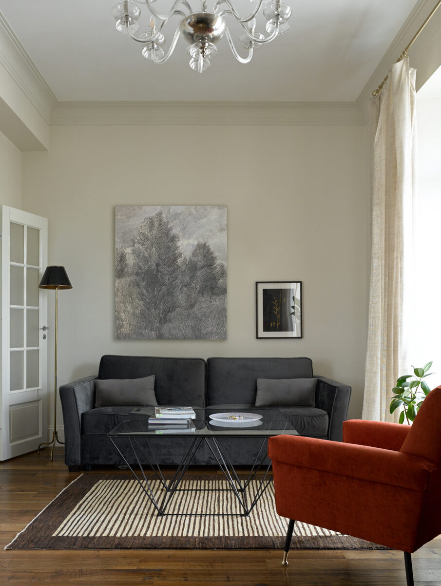 Гостиная. Винтажный журнальный столик по дизайну Паоло Пивы; итальянское кресло 1950-х годов из салона Repeat Story; торшер 1936 года по эскизам Джозефа Франка; ковер из “Декораторского ателье Марка Патлиса”; над диваном картина Екатерины Рожковой.