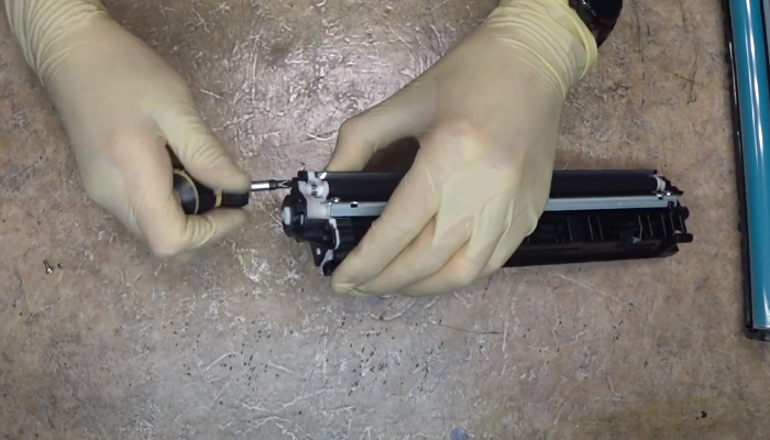 Фото 53. Очищаем при помощи сервисного пылесоса отверстие рядом с дозирующим лезвием, через которое высыпали остатки тонера