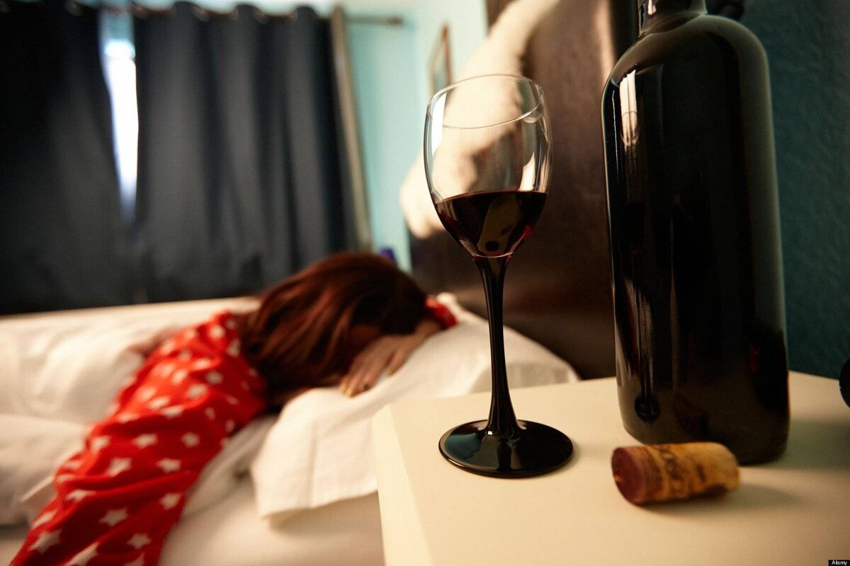 Женщина с бокалом вина в постели