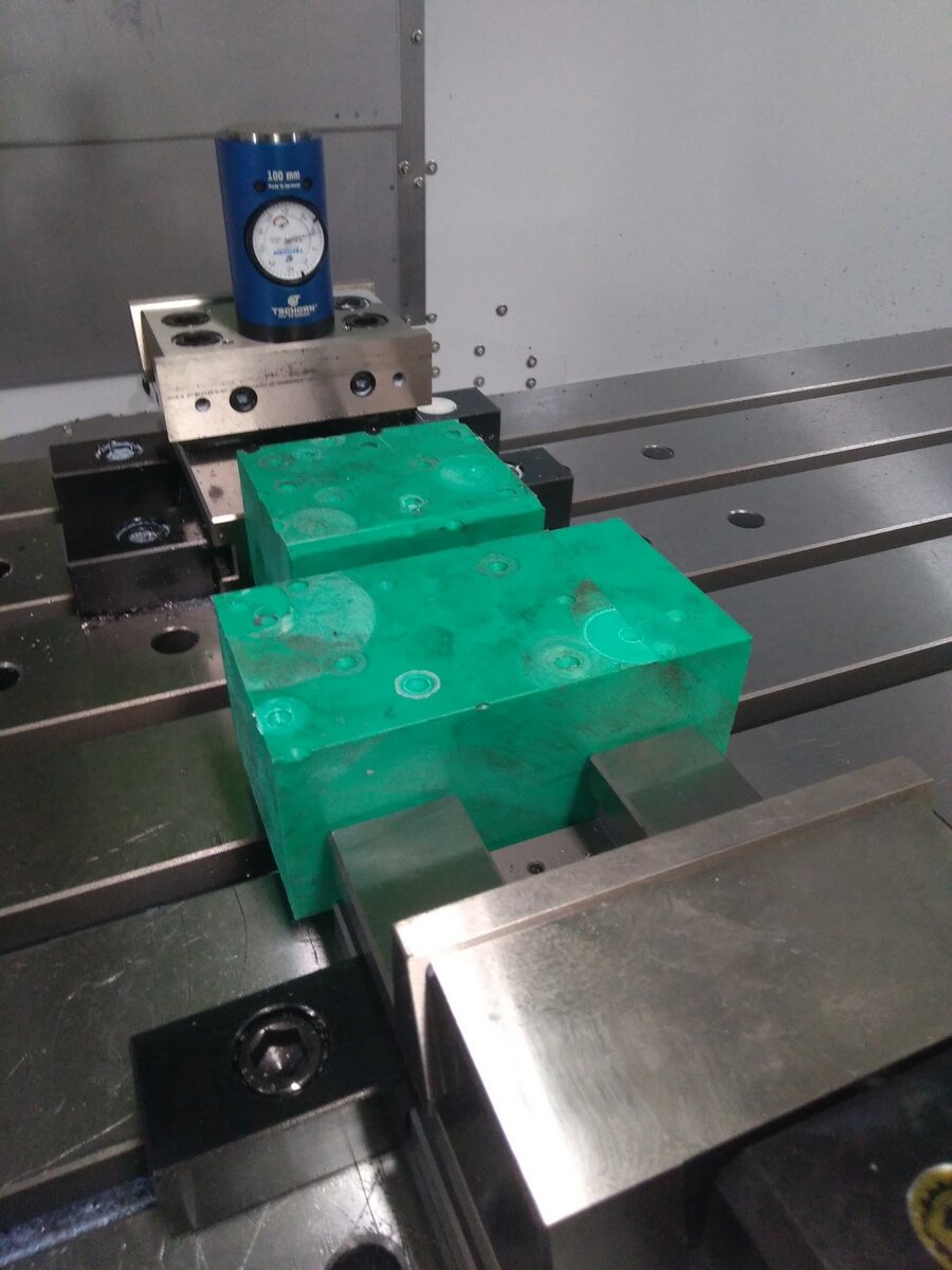 Стакан 100мм на заднем плане. Простейшая система, давишь сначала пустым шпинделем на пятак стакана, обнуляешь координату Z, потом вставляешь оправку с фрезой в шпиндель и уже концом фрезы тыкаешь в пятак до совмещения стрелки с нулем. Полученную разницу заносишь в таблицу корректоров. Зеленое - модельный пластик SicaBlock 945