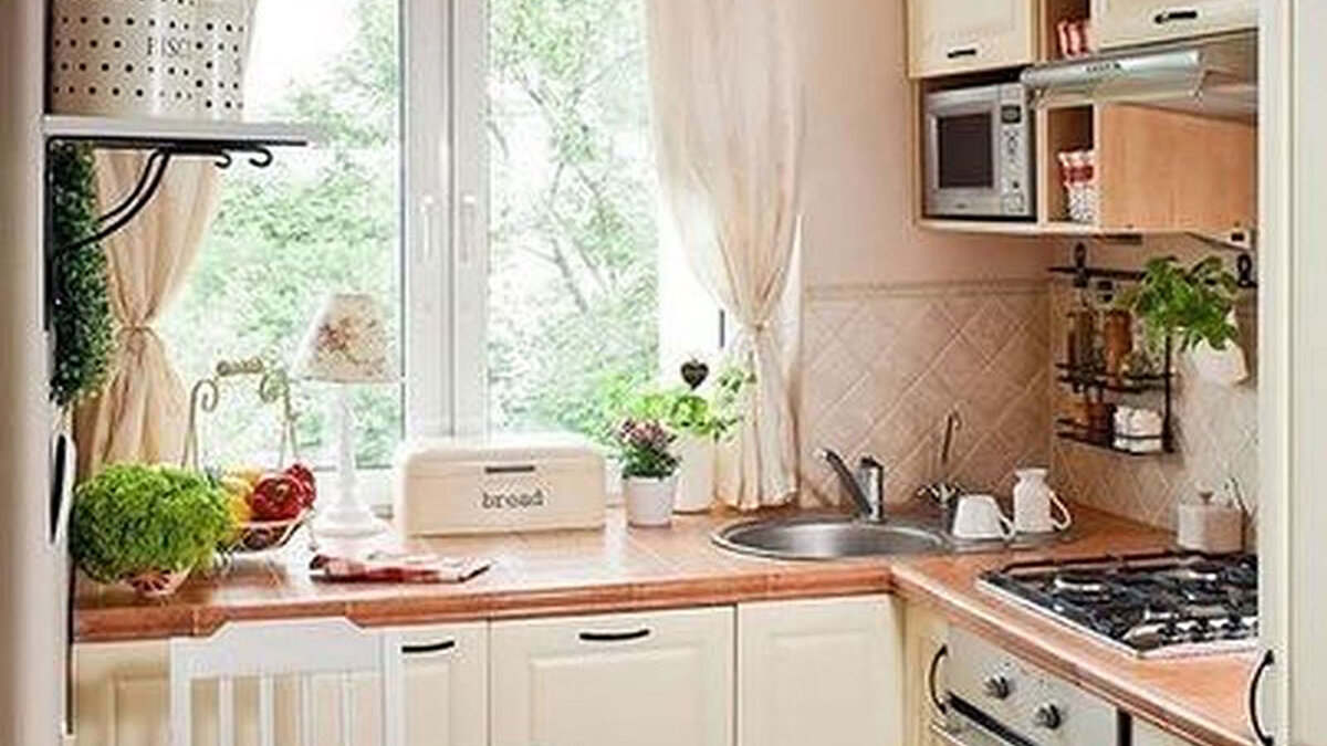 Легкие занавески в интерьере кухни малой площади.