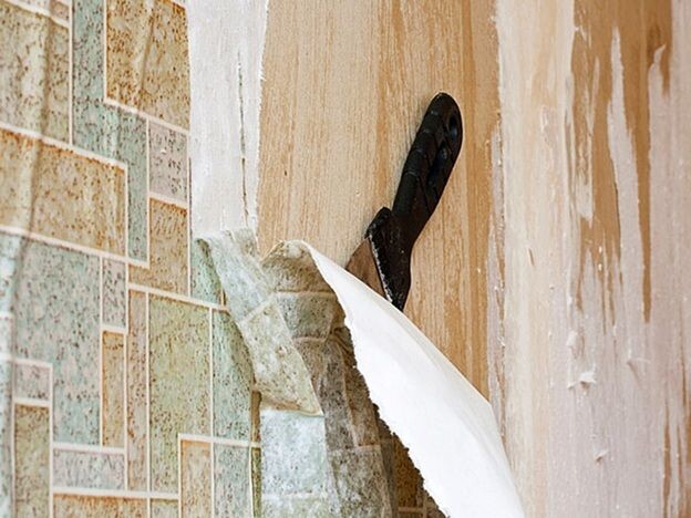 Как видно на фото, не всегда удается снять старое покрытие. Остатки снова смачивают и удаляют шпателем.