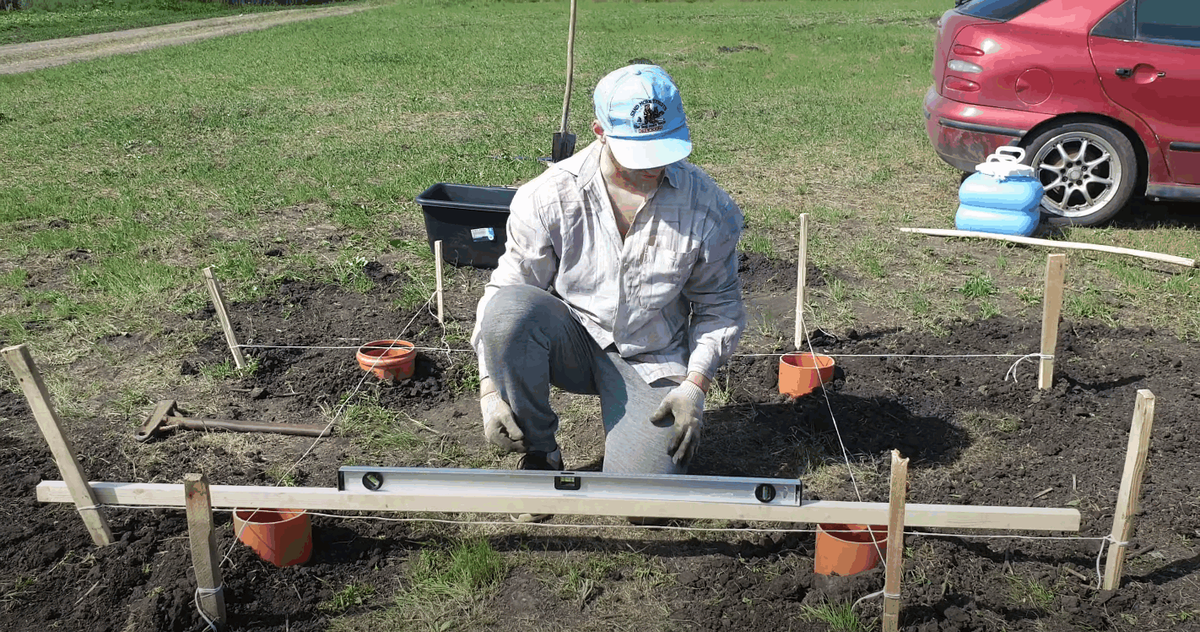 Колышки и ниточка - обязательно проверяем все диагонали и сверяем по уровню все стороны. Все должно быть ровно и красиво.  В синей бочке вода.                                     
Фото: Станислав Спесивцев/Dinar

