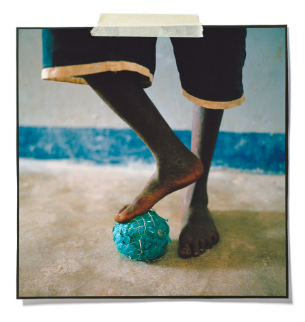 Карлос Рибейро стоит на мяче, который сделал из мусора в Иньярриме. Мозамбикские мальчики обучаются искусству делать мячи начиная с пяти лет. Фото: Джессика Хиллту